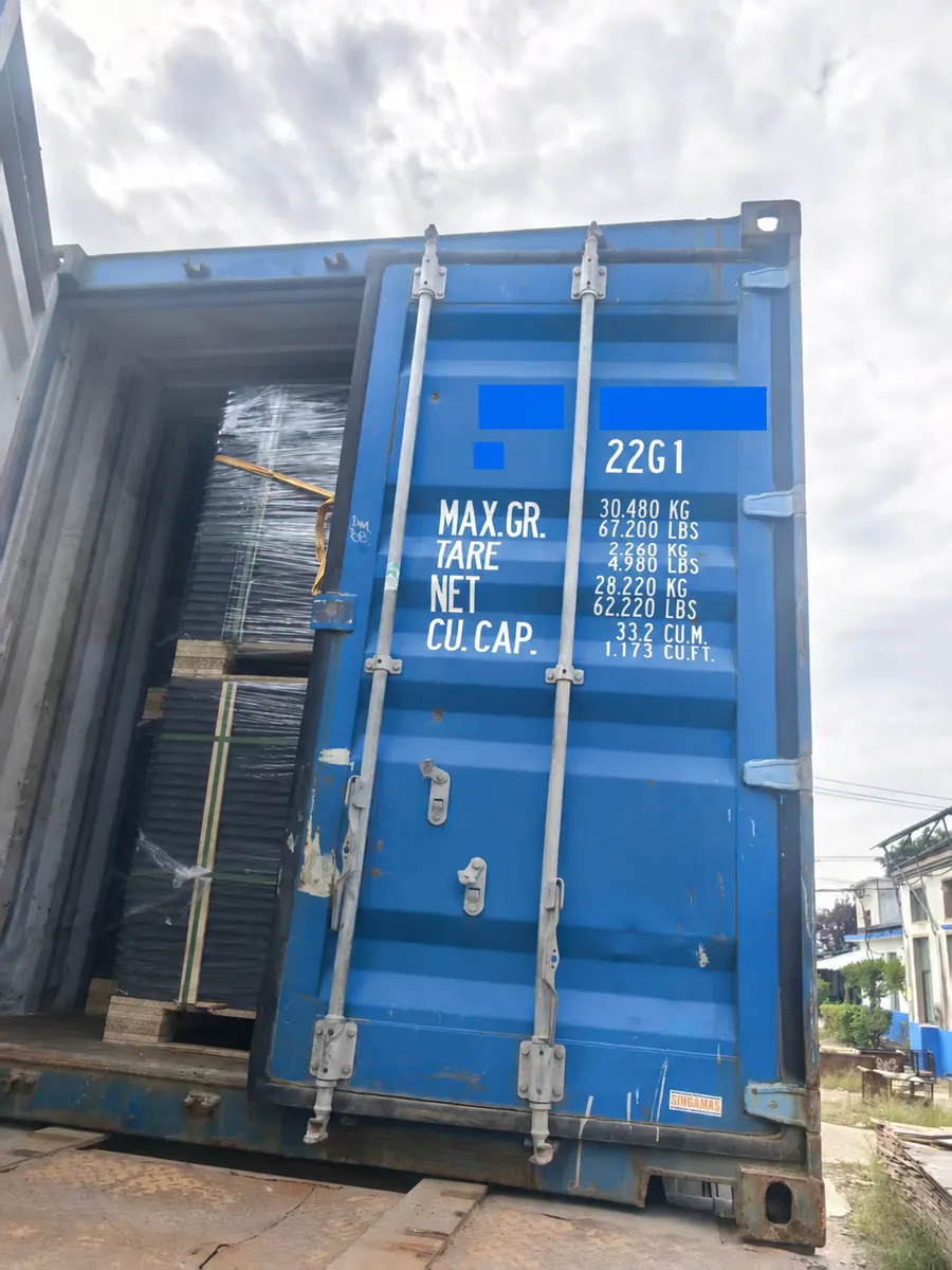 Blue shipping container with doors and wrapped raised floor pallets visible